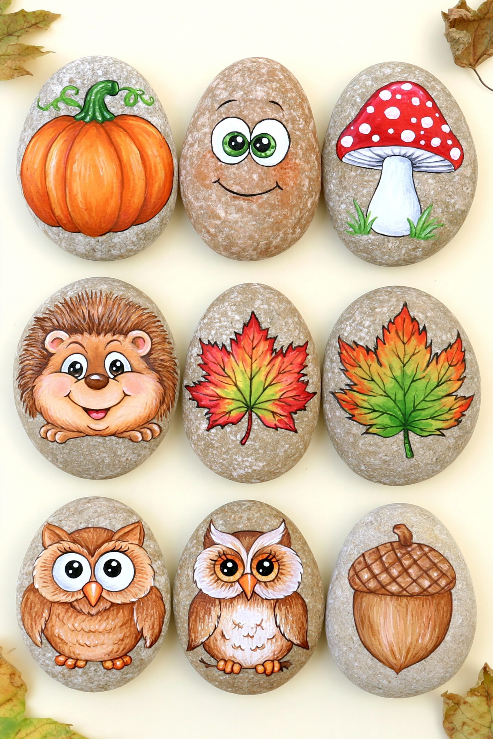 Neun bemalte Herbststeine mit Kürbis, Pilz, Igel, Blättern, Eulen und Eichel